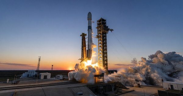 Launch vehicle on pad at sunrise with rocket exhaust plume
